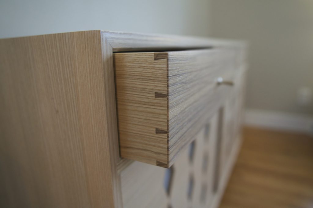 Closeup detail of a dovetailed drawer partially open
