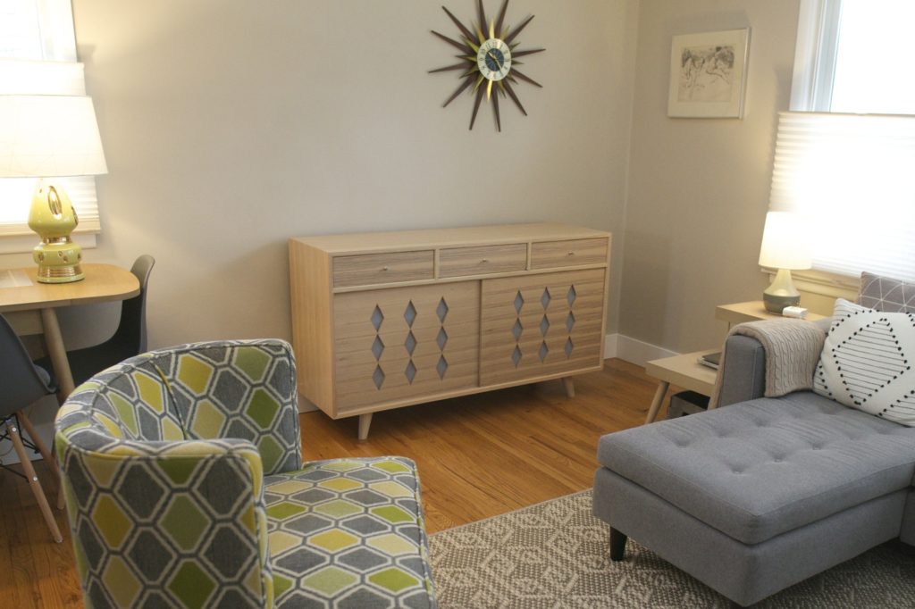 Mid century modern record console in the middle of a well decorated room