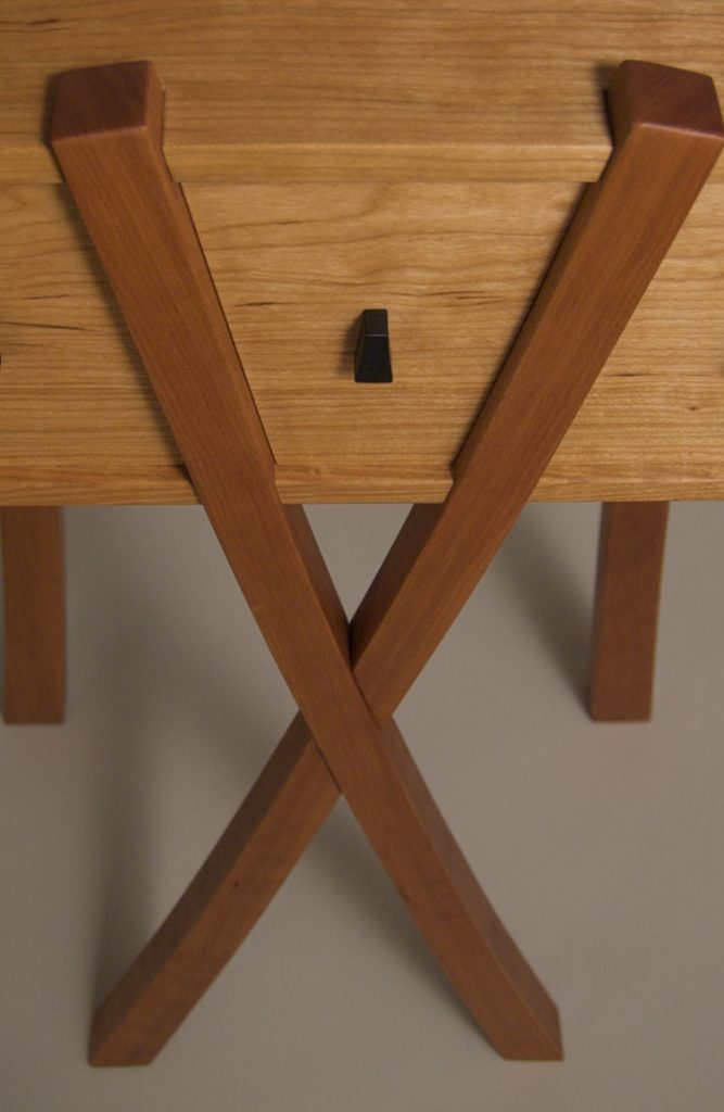 treehouse table with three angled drawers looking down at the X legs
